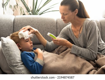 Mother taking her sick child's temperature. Mom taking care of child at home with fever.  - Powered by Shutterstock