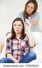 Mother Taking Mobile Phone Away From Teenage Daughter