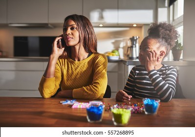 Mother talking on phone forgetting child that wants to play