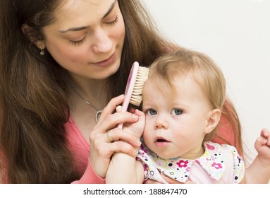 Mother Is Teaching The Baby Of 11 Months Old To Brush Hair.