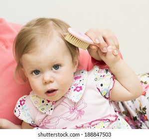 Mother Is Teaching The Baby Of 11 Months Old To Brush Hair.