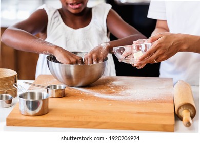 Mother Teaching Child to Cook and Help in the Kitchen. African American Mother and Daughter making cookies at home.  - Powered by Shutterstock