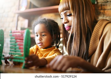 Mother teaching daughter to accounting. 