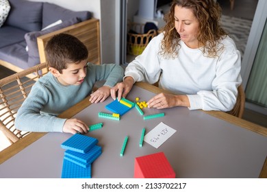 Mother teaching her son math with base 10 method at home - Powered by Shutterstock