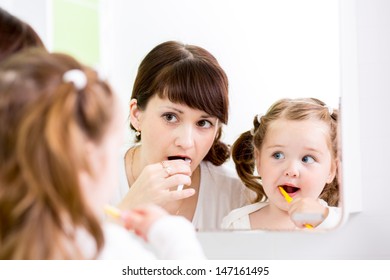 mother teaching kid teeth brushing