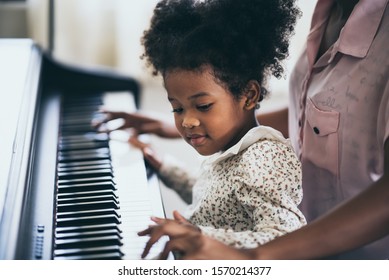 Mother is teaching piano tricks, African people - Powered by Shutterstock