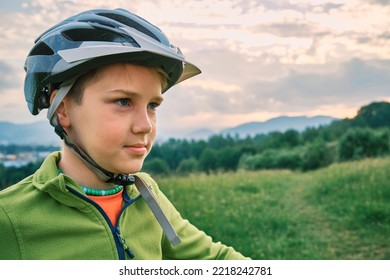 Mother Teaching Son To Ride Bicycle. Happy Cute Boy In Helmet Learn To Riding A Bike In Park On Green Meadow In Summer Day At Sunset Time. Family Weekend. 4K Video Slow Motion