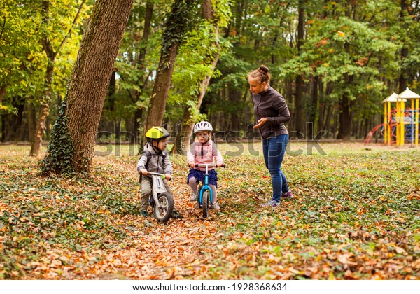 Mother\
teaching and supporting their kids on bike\
ride