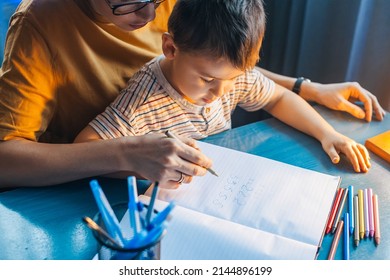 Mother Teaching Writing Math Number Her Son At Home. Mom And Boy Hand In Hand Writing Numbers, Great Design For Any Purposes.