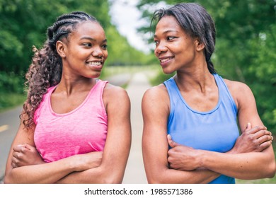 A Mother And Teen Daughter Running In Green Park In Summer Time