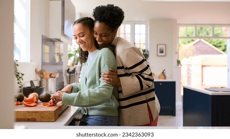 Mother With Teenage Daughter Helping To Prepare Meal At Home In Kitchen Together - Powered by Shutterstock