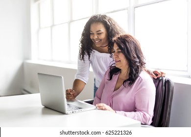 A Mother And Teenage Daughter Looking At Laptop Together - Powered by Shutterstock