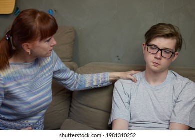 Mother And Teenage Son Are Talking At Home With Family Relationships On The Couch. High Resolution Photos