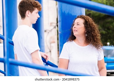 Mother And Teenage Son Talking On The Street