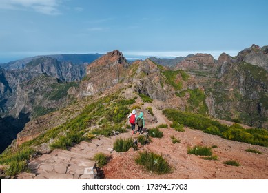 Mother with teenager son trekking the famous mountain footpath from Pico do Arieiro to Pico Ruivo on the Portuguese Madeira island. Around the world traveling with kids concept image.