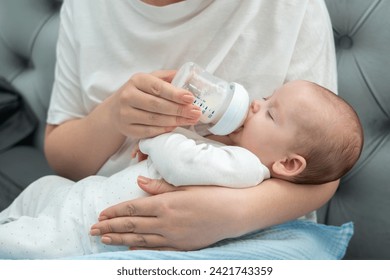 Mother tenderly feeds newborn with milk formula, Concept of modern parenting and nourishment - Powered by Shutterstock