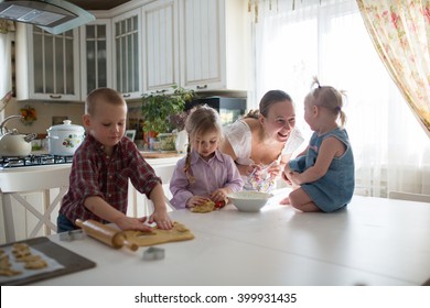 Mother With Three Children In The Kitchen Preparing Cookies, Large Family. Casual Lifestyle Photo Series In Real Life Interior