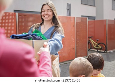 Mother of three children, Ukrainian refugee, thanking to senior woman in Europe for clothes and toys she gave to support them. Humanitarian aid and helping hand from world for Ukraine during the war - Shutterstock ID 2137631485