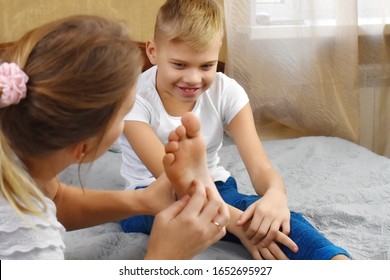 Mother tickles the child. Tickling and laughter. Mother and son together having fun. Mother touch baby son. Games with children at home