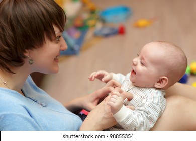 The Mother Tickles Her Baby Boy At Home