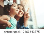 Mother, toddler and happy or home window, love and bonding with family in apartment together with girl baby. Childhood development, growth and smile or caring, woman and hand pointing in house