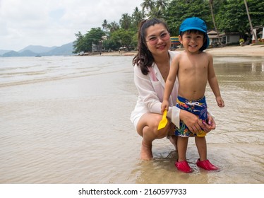 Mother Took Her 3 Year Old Son Come Play In The Sea And Poses For A Photo With The Child