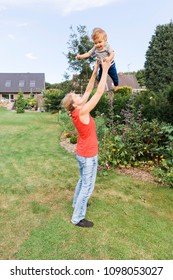 Mother Tossing Baby In The Air 