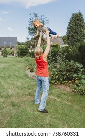 Mother Tossing Baby In The Air