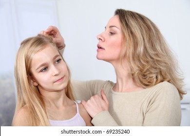 Mother Treating Daughter's Hair Against Lice