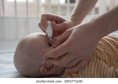 Mother Is Treating Newborn Eye Inflammation By Givining Eye Drops.