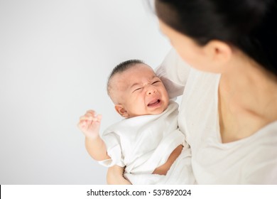 Mother trying to comfort her crying baby isolated