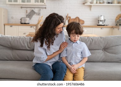 Mother Trying To Distract Upset Kid. Young Mom Engaging Depressed Offended Son In Bad Mood By Hug. Child And Parent Relationship. Worried Woman Talk To Frustrated Little Boy After Fight Or Quarrel