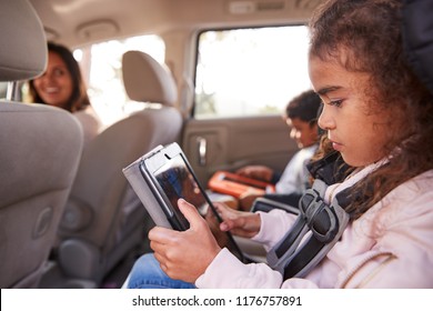 Mother Turns Around To Kids Using Tablets In The Back Of Car