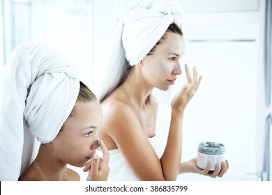 Mother and tween daughter make a clay facial mask, family skin care in the bathroom - Powered by Shutterstock