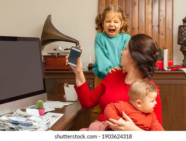 Mother With Two Child At Home. Kids Crying. Childcare And Working Mom. Woman Talk By Phone. Toddler Tantrum. Young Lady Working At Home During Quarantine. Real People. A Lot Of Bills On The Table.