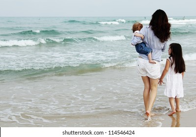 Mother With Two Daughters On The Beach