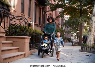 Mother and two daughters taking a walk down the street