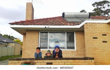 Mother And Two Kids In Front Of House During Winter In Perth, Australia