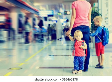 Mother And Two Kids Walking In The Airport, Family Travel