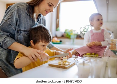 Mother of two little children preparing breakfast in kitchen at home. - Shutterstock ID 2184937853