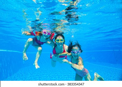 mother with two little girls played under water in the pool - Powered by Shutterstock