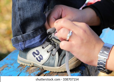 Mother Tying Little Shoes Outdoor