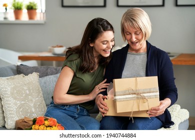 Mother unpacking a gift with her adult daughter                               