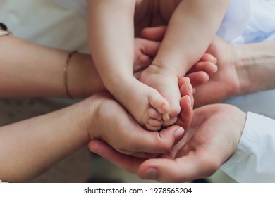 Mother Uses Her Hand To Hold Her Baby's Tiny Hand To Make Him Feeling Her Love, Warm And Secure.