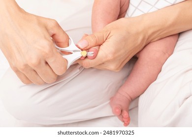 Mother uses special baby nail scissors to cut toenails of newborn baby - Powered by Shutterstock