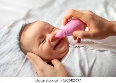 Mother Using Baby Nasal Aspirator Mucus Nose Suction