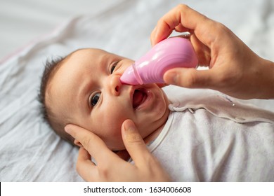 Mother Using Baby Nasal Aspirator Mucus Nose Suction