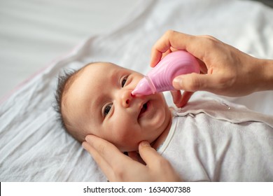 Mother Using Baby Nasal Aspirator Mucus Nose Suction