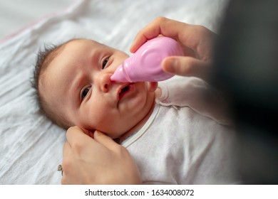 Mother Using Baby Nasal Aspirator Mucus Nose Suction