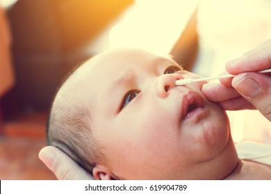 Mother Using Cotton Swap Pick Up Nose A Babies Newborn. 